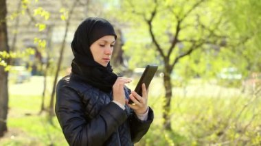 Müslüman kadının elleri açık havada bir tablet ile. Dolu hd video