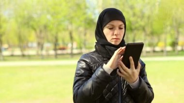Müslüman kadının elleri açık havada bir tablet ile. Dolu hd video