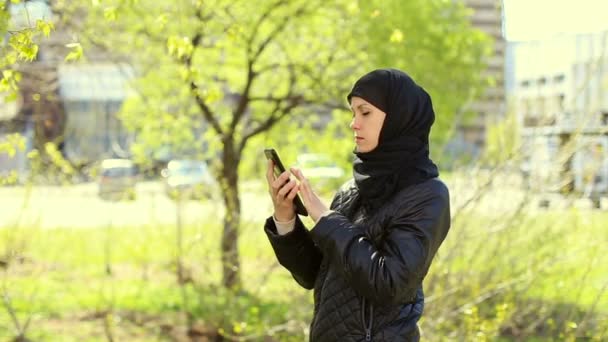 在她的手在户外的平板电脑的穆斯林妇女。完整的高清视频 — 图库视频影像