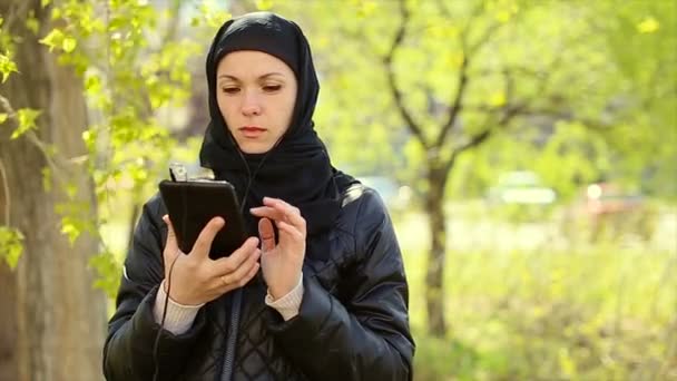 Muslimská žena s tabletem v ruce venku. Plné hd video — Stock video