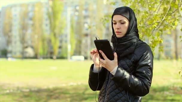 Μουσουλμανική γυναίκα με ένα tablet στα χέρια της σε εξωτερικούς χώρους. Πλήρες βίντεο hd — Αρχείο Βίντεο