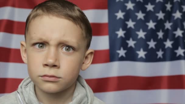 El retrato del chico en el fondo de la bandera americana. De cerca. — Vídeos de Stock