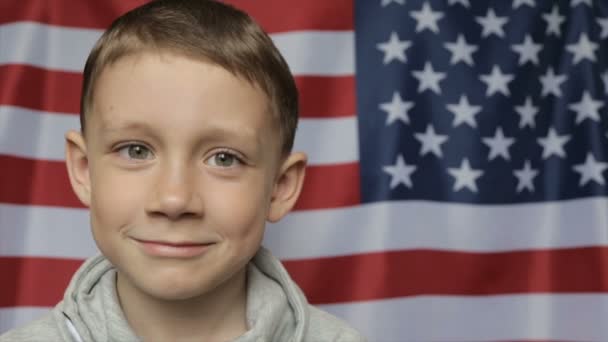 El retrato del chico en el fondo de la bandera americana. De cerca. — Vídeos de Stock