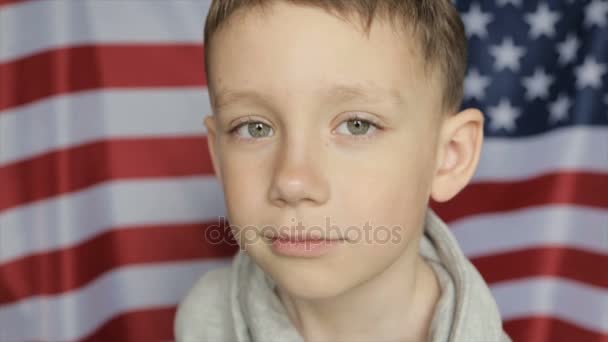 O retrato do rapaz no fundo da bandeira americana. Fechar — Vídeo de Stock