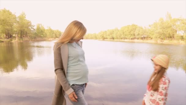 怀孕的妈妈和女儿玩在湖边 — 图库视频影像