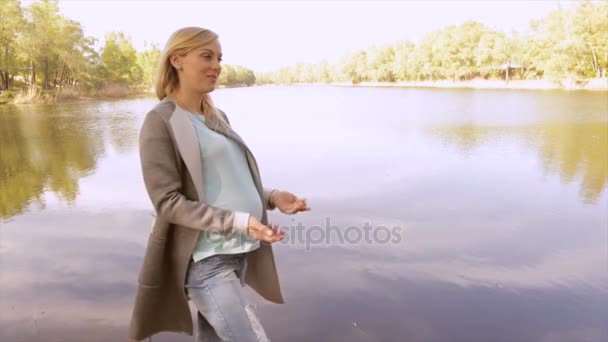 Schwangere Mutter und Tochter spielen am See — Stockvideo