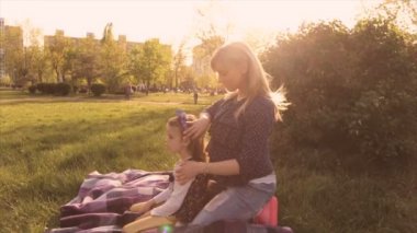 Mutlu aile, anne ve kızı çayırda oynarken