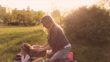 Mutlu aile, anne ve kızı çayırda oynarken