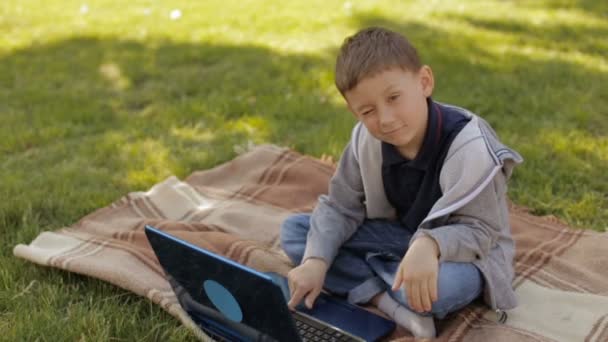 Мальчик с ноутбуком на улице, замедленная съемка — стоковое видео