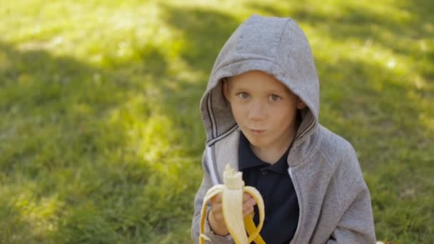 Roztomilý chlapec jí banán — Stock video