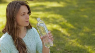Bir kız doğa içme suyu plastik bir şişe