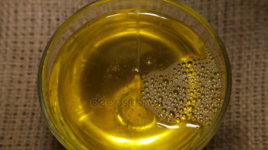 Ayçiçeği tohumu yağı yakın çekim döndürme, bir cam kabın içinde. Dolu hd video