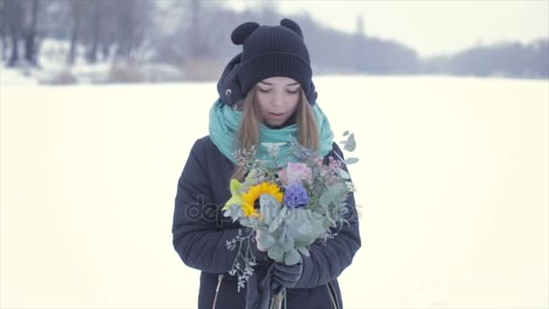 凍った湖の上に花の花束を持つ少女。スローモーション — ストック動画