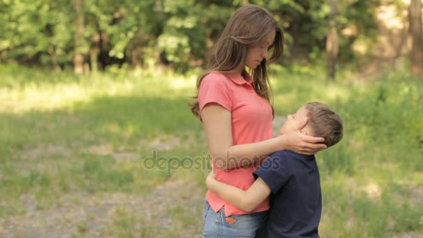 Мама нежно обнимает сына в парке. — стоковое видео
