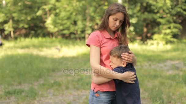 Mamá gentilmente abraza a su hijo en el parque — Vídeo de stock