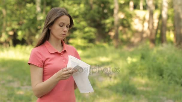 Chica con un paquete de documentos en el parque — Vídeo de stock
