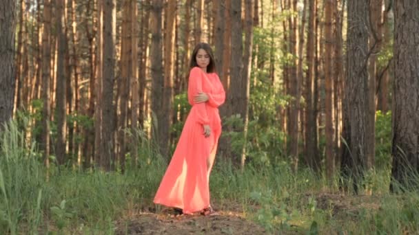 Κορίτσι στο φόρεμα στο κόκκινο χρώμα στο δάσος — Αρχείο Βίντεο