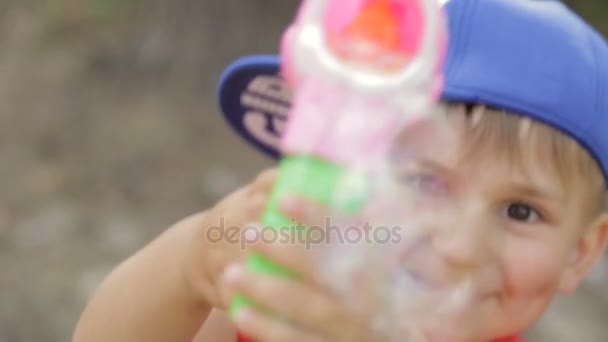 The boy plays with soap bubbles — Stock Video