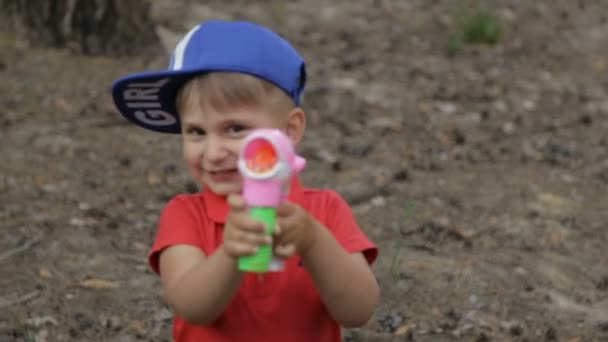 Хлопчик грає з мильними бульбашками — стокове відео