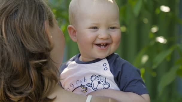 The boy laughs in his mothers arms — Stock Video