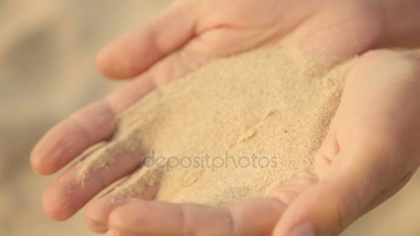 Sea sand is poured from women's hands — Stock Video