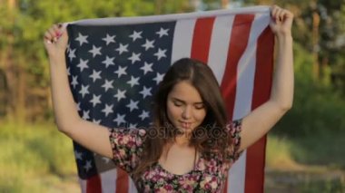 Kız ellerinde Amerikan bayrağı ile gün batımında