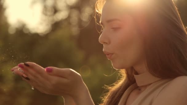 La chica sopla polvo de oro de sus manos — Vídeos de Stock