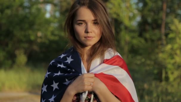 Meisje bij zonsondergang met de Amerikaanse vlag in handen — Stockvideo
