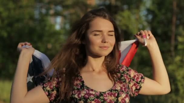 Chica al atardecer con bandera americana en las manos — Vídeos de Stock
