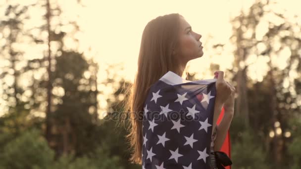 Chica al atardecer con bandera americana en las manos — Vídeos de Stock