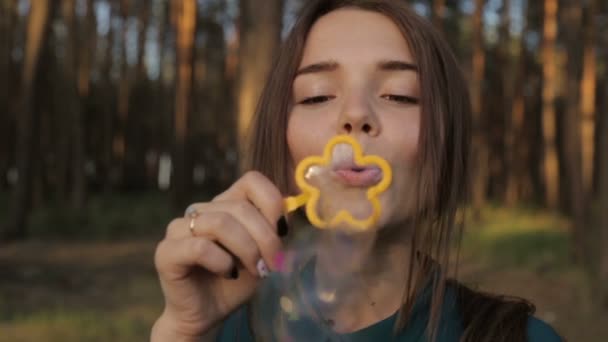 Belle fille soufflant des bulles de savon 