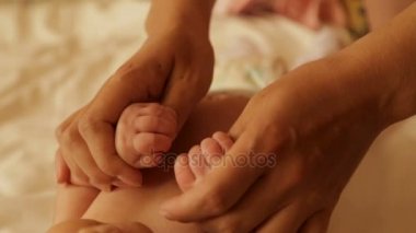 Anne, şefkatle bebeğin küçük eller kucakladı