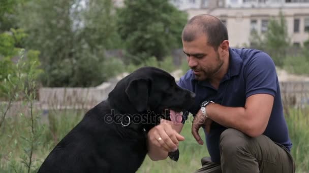 En man utbildar sin hund — Stockvideo