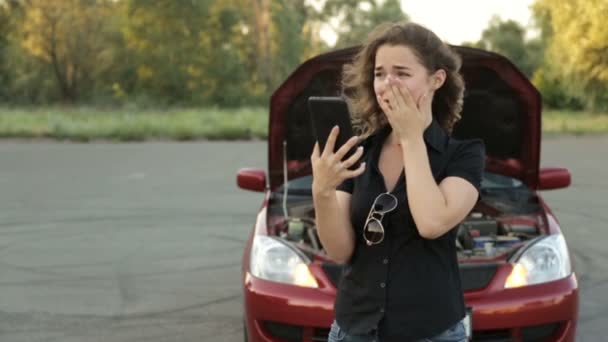 Een onrustig meisje en een kapotte auto op de weg. Een oproep tot de autodienst — Stockvideo