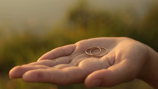 Обручальные кольца на ладони женщины — стоковое видео