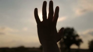 Akşam güneşinin parıltısı parmaklarıyla