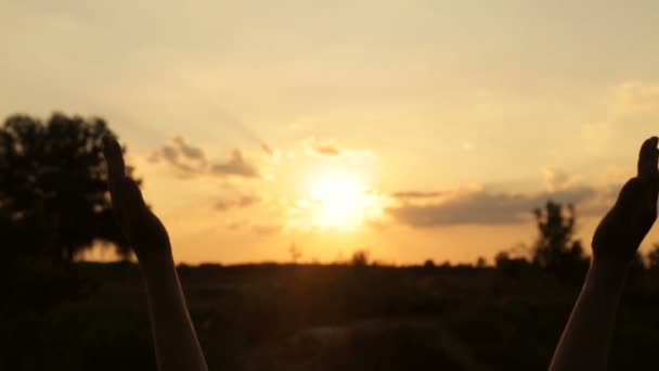 Deslumbramiento del sol poniente a través de las manos de las mujeres — Vídeo de stock
