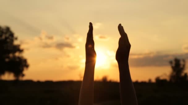 Éblouissement du soleil couchant à travers les mains des femmes — Video