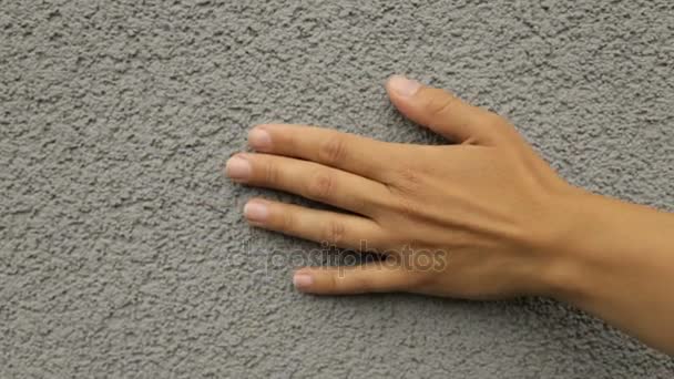 Женская рука нежно гладит текстурную стену — стоковое видео