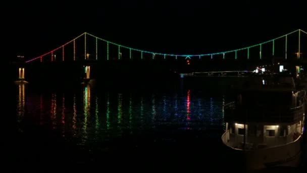 Η γέφυρα πέρα από τον ποταμό που τονίζεται από χρωματιστά φανάρια — Αρχείο Βίντεο