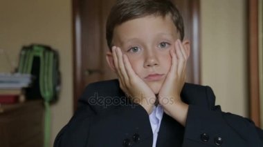 Bir öğrenci okul üniformalı bir masada oturur