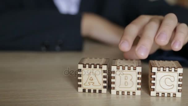 Ten chlapec složí kostky s písmena anglické abecedy — Stock video