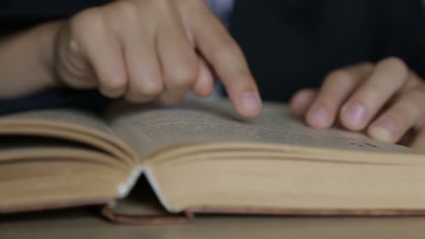 A criança está lendo um livro. Os braços dos meninos têm 6-7 anos — Vídeo de Stock