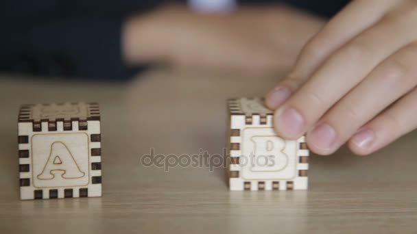 Le garçon plie des cubes avec des lettres anglaises — Video