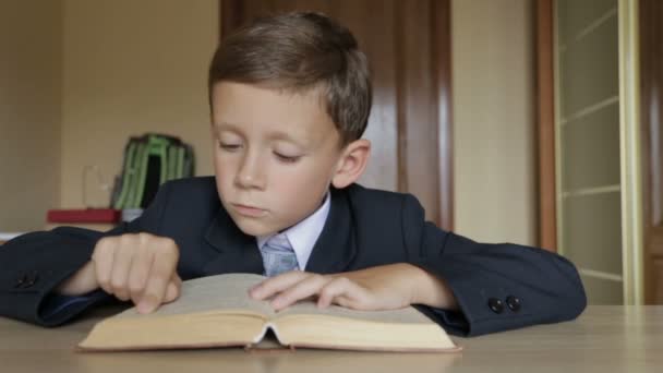 A criança está lendo um livro. Os braços dos meninos têm 6-7 anos — Vídeo de Stock