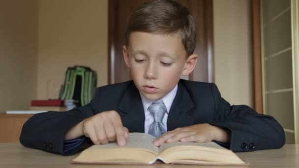 Barnet läser en bok. Pojkar armarna är 6-7 år — Stockvideo