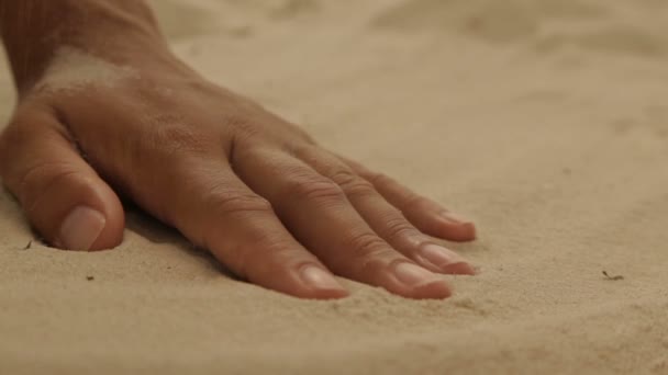 Trockener Meeressand auf einer Frauenhand — Stockvideo