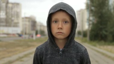 Sokakta siyah başlıklı bir çocuk.