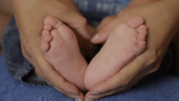 Mãe segura os pés do bebê nas mãos — Vídeo de Stock