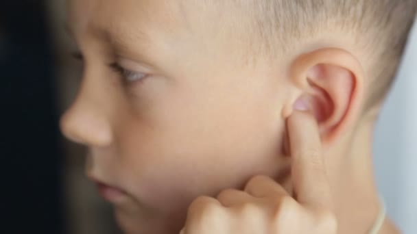 El dedo del niño masajea la oreja izquierda — Vídeo de stock